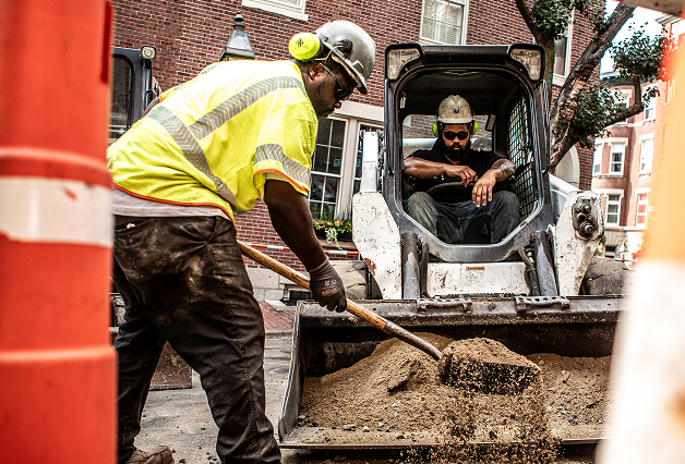 man digging and man on a skid steer
