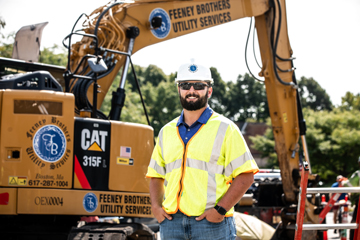 employee with excavator in background